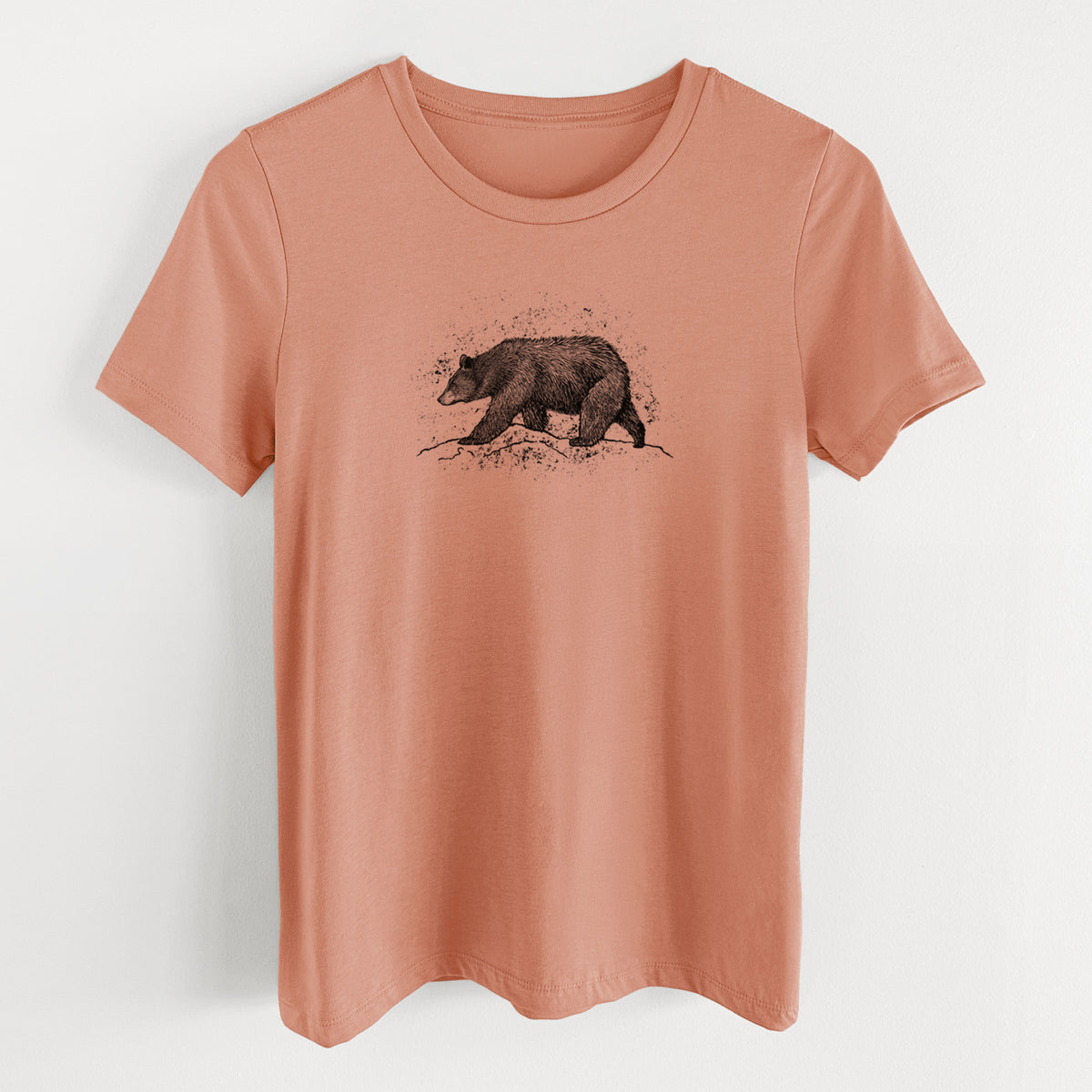 Terracotta orange women's relaxed fit cotton t-shirt laid flat, printed with a detailed black ink sketch of a black bear walking across rocky ground.