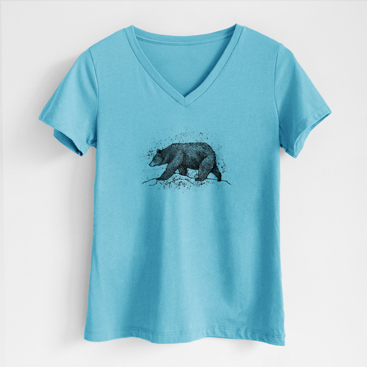 Turquoise women's relaxed fit cotton V-neck t-shirt laid flat, printed with a detailed black ink sketch of a black bear walking across rocky ground.