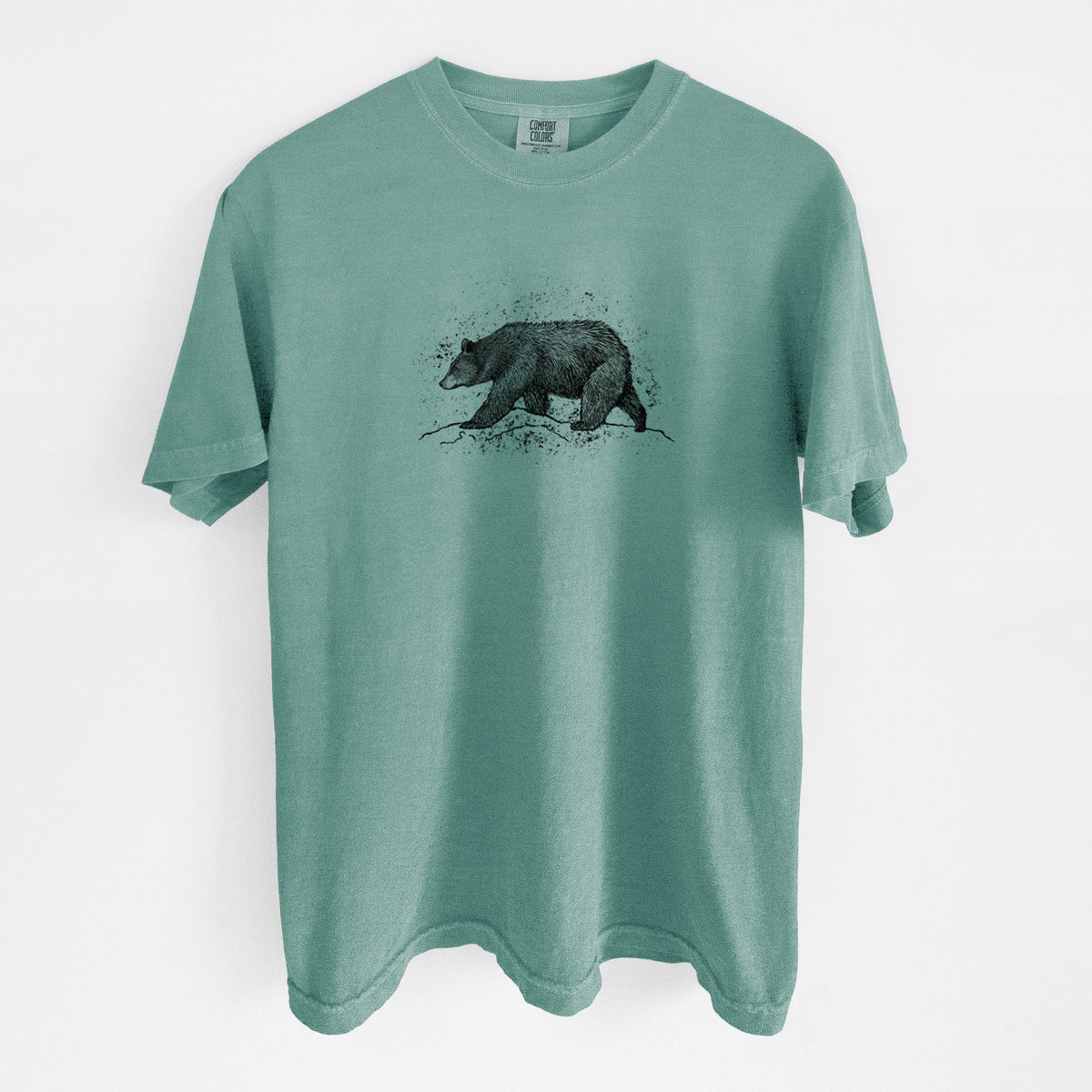 Reef green Comfort Colors t-shirt laid flat, printed with a detailed black ink sketch of a black bear walking across rocky ground.