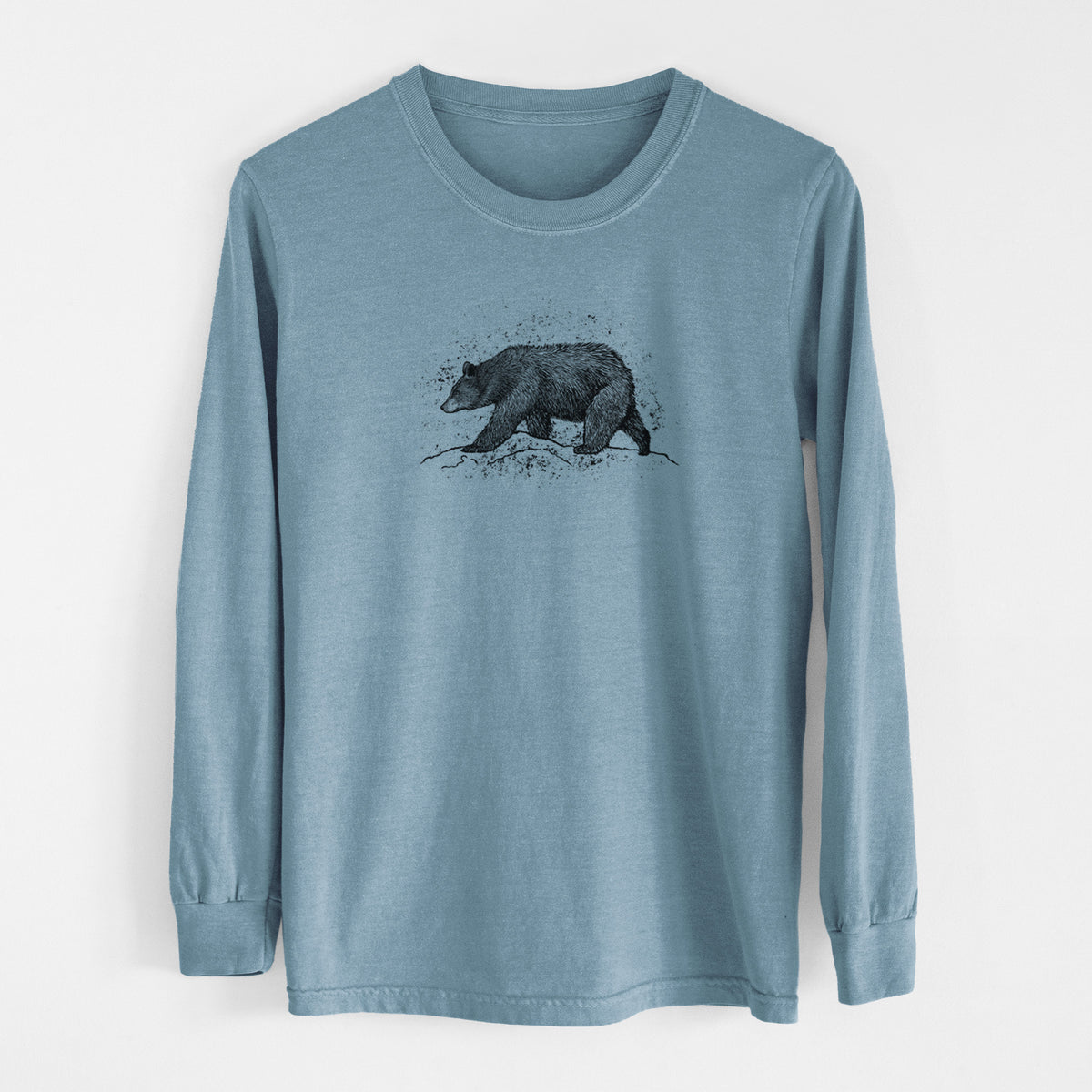 Steel blue Comfort Colors long sleeve shirt laid flat, printed with a detailed black ink sketch of a black bear walking across rocky ground.