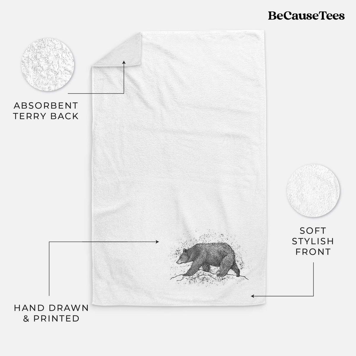 White hand towel printed with a detailed black ink sketch of a black bear walking across rocky ground.