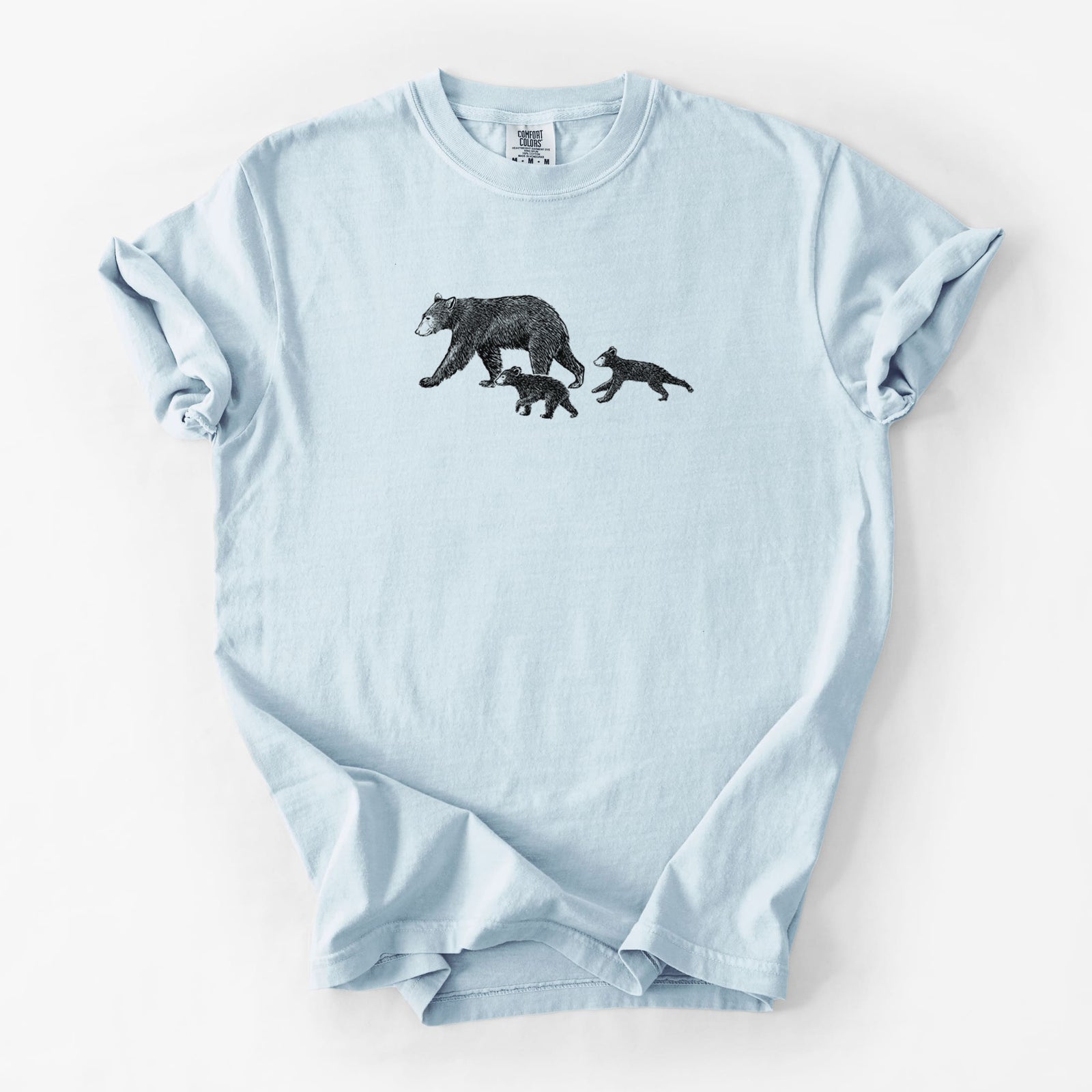 Blue jean Comfort Colors t-shirt laid flat, printed with a black ink illustration of a mother black bear walking with two cubs.