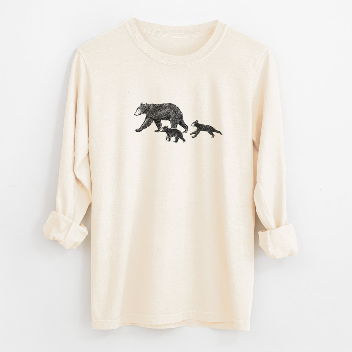 Ivory Comfort Colors long sleeve shirt laid flat with the cuffs rolled, printed with a black ink illustration of a mother black bear walking with two cubs.