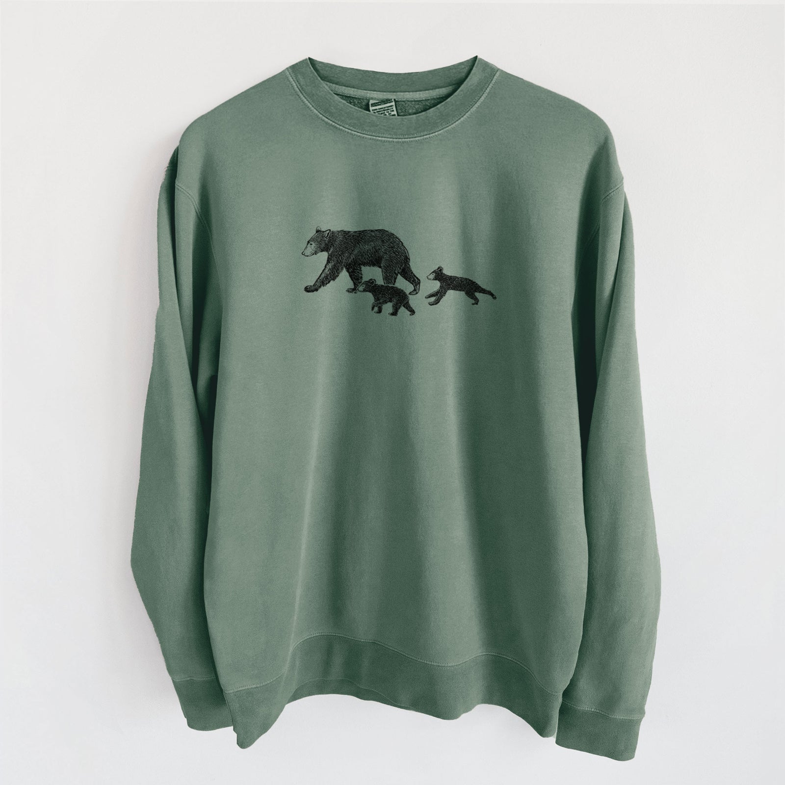 Alpine green pigment dyed crewneck sweatshirt laid flat, printed with a black ink illustration of a mother black bear walking with two cubs.