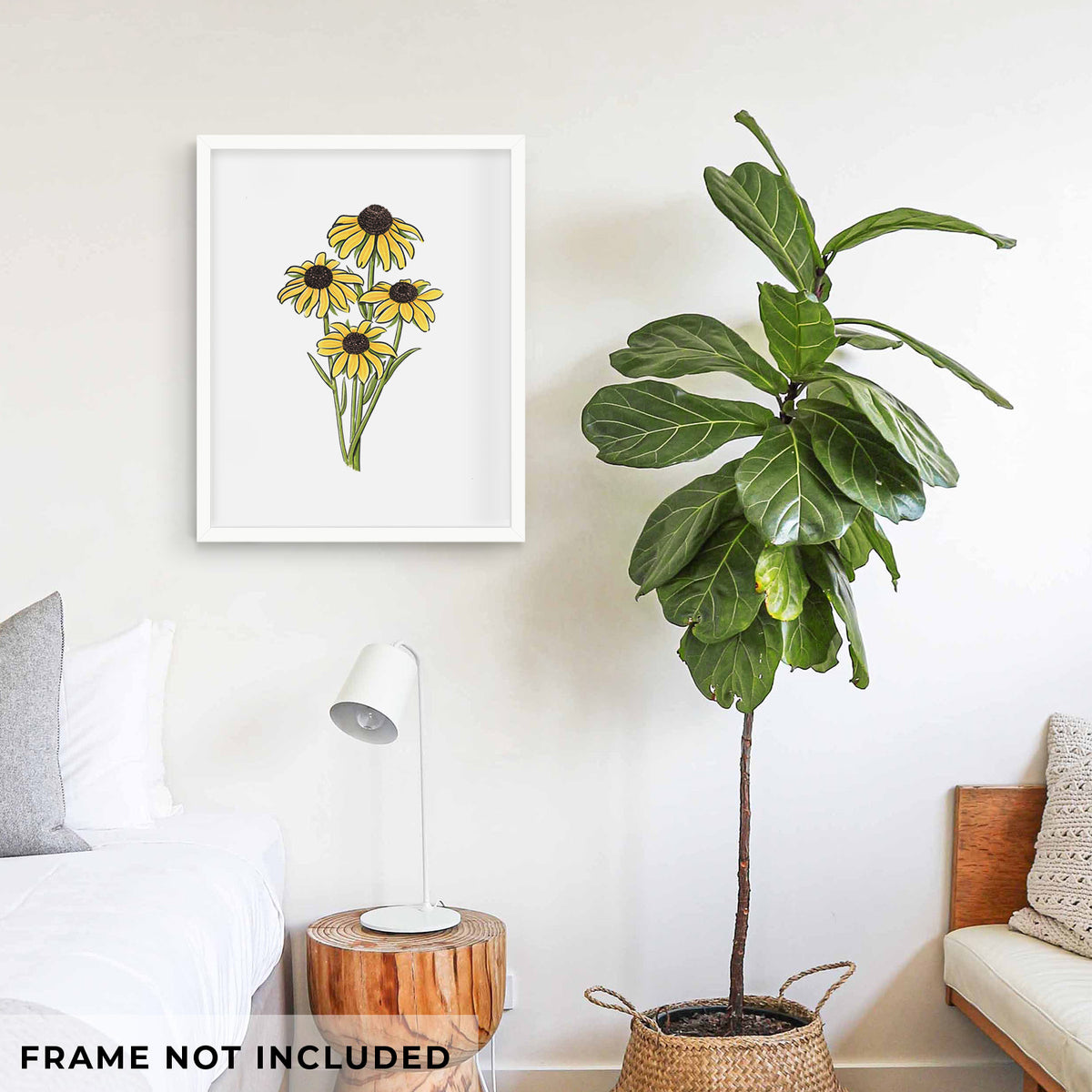 Art print of a full-color bouquet of yellow black-eyed Susan flowers, shown framed on a living room wall beside a potted plant. Frame not included.