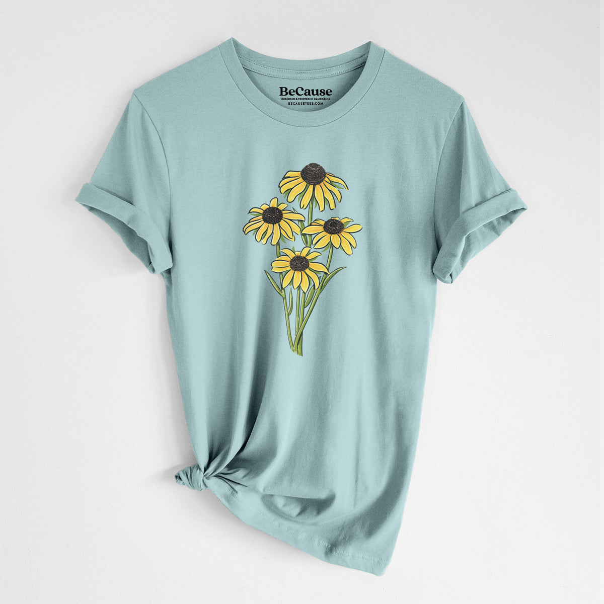 Dusty blue lightweight cotton t-shirt laid flat with the sleeves rolled, printed with a full-color bouquet of yellow black-eyed Susan flowers.