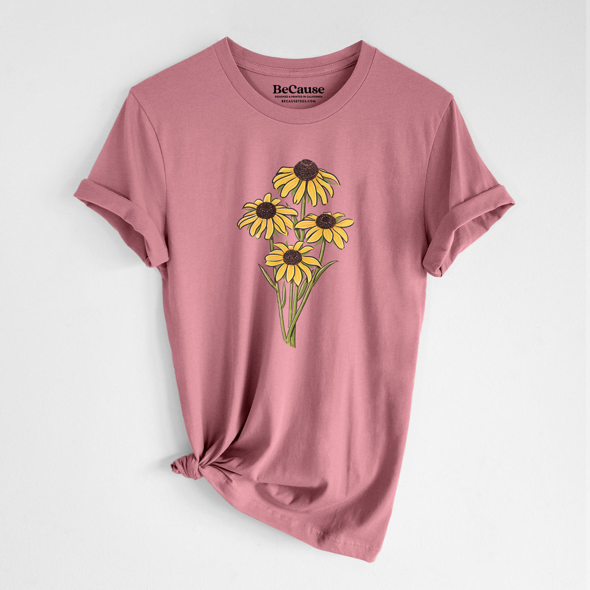 Mauve pink lightweight cotton t-shirt laid flat with the sleeves rolled, printed with a full-color bouquet of yellow black-eyed Susan flowers.