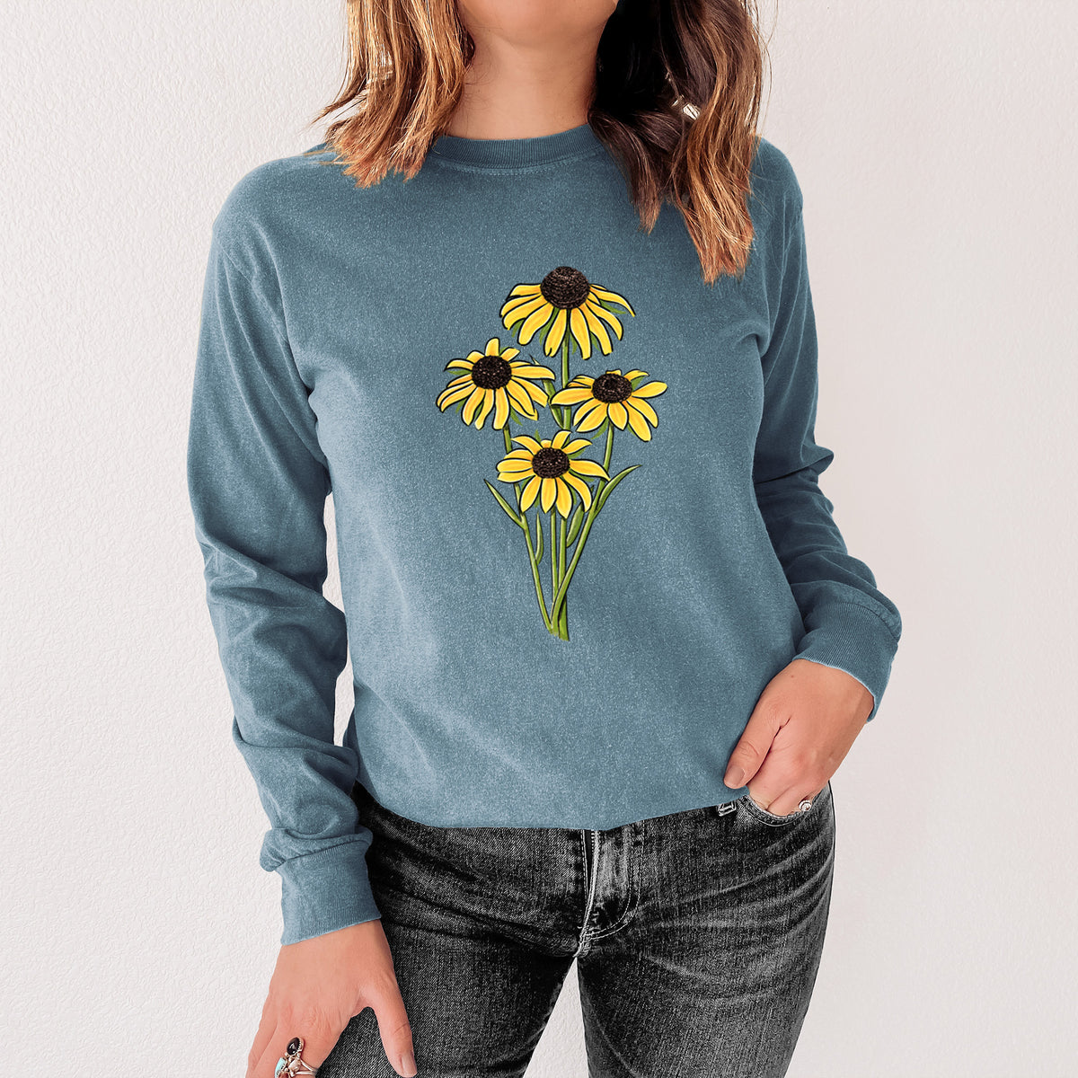 Steel blue Comfort Colors long sleeve shirt printed with a full-color bouquet of yellow black-eyed Susan flowers, shown in a lifestyle photo.