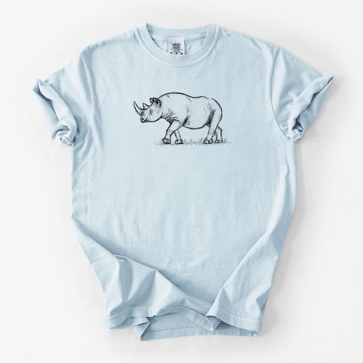 Chambray blue Comfort Colors t-shirt laid flat, printed with a black ink illustration of a black rhinoceros walking.