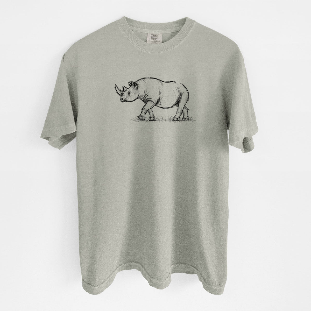 Sandstone beige Comfort Colors t-shirt laid flat, printed with a black ink illustration of a black rhinoceros walking.