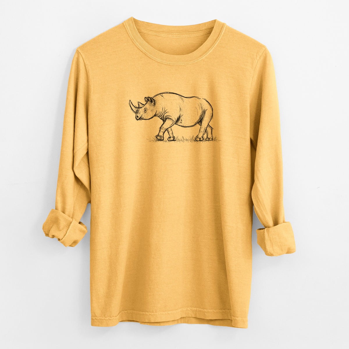Golden wheat yellow Comfort Colors long sleeve shirt laid flat with the cuffs rolled, printed with a black ink illustration of a black rhinoceros walking.