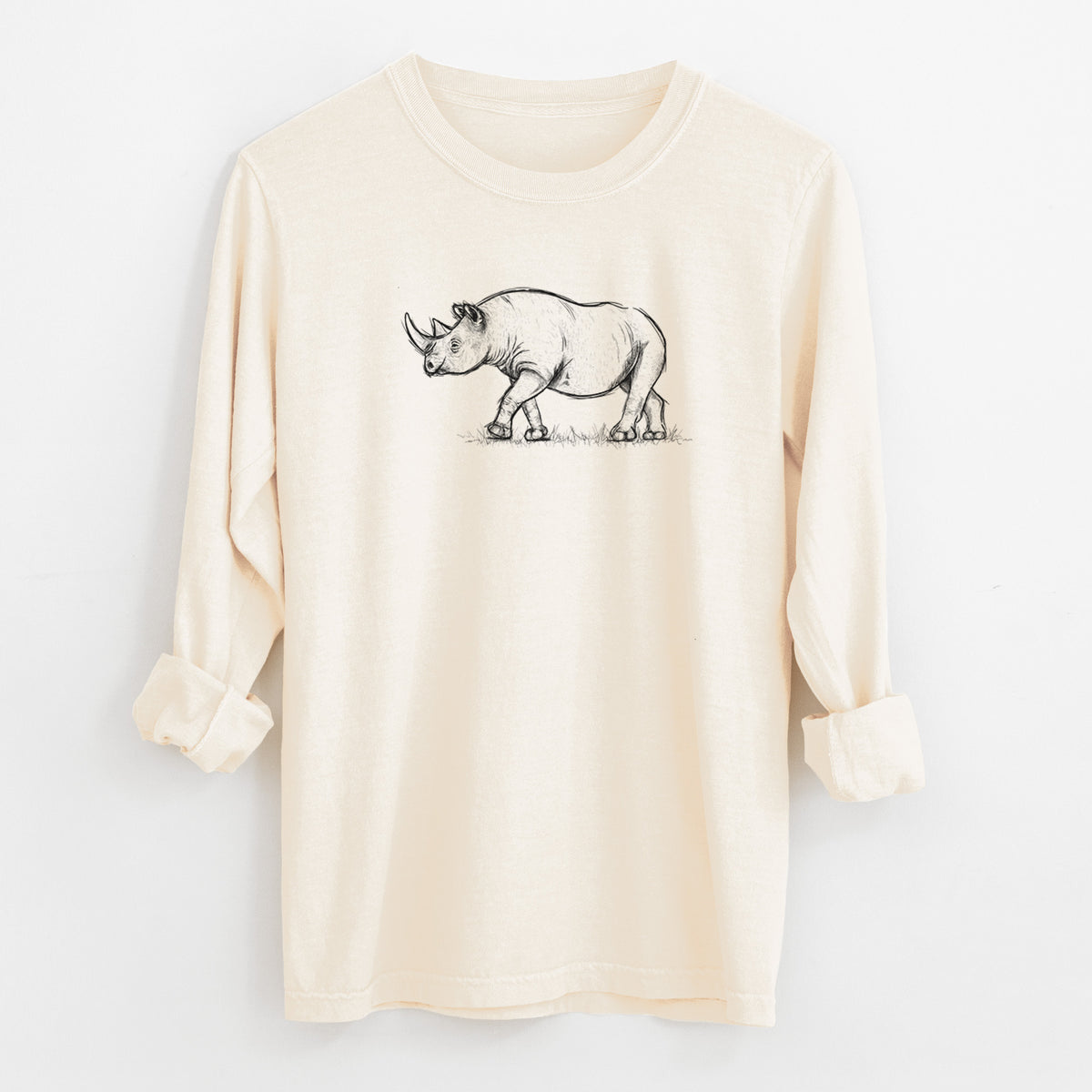Ivory Comfort Colors long sleeve shirt laid flat with the cuffs rolled, printed with a black ink illustration of a black rhinoceros walking.