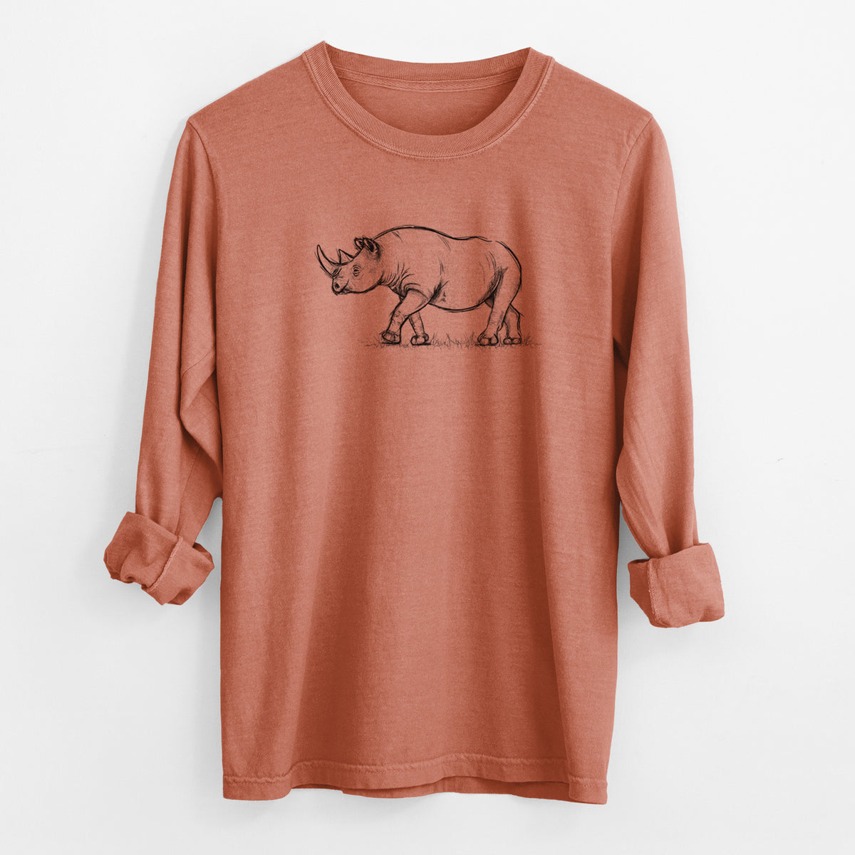 Yam burnt orange Comfort Colors long sleeve shirt laid flat with the cuffs rolled, printed with a black ink illustration of a black rhinoceros walking.