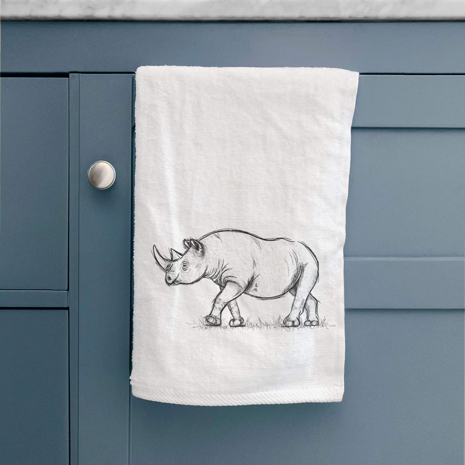 White hand towel printed with a black ink illustration of a black rhinoceros walking.