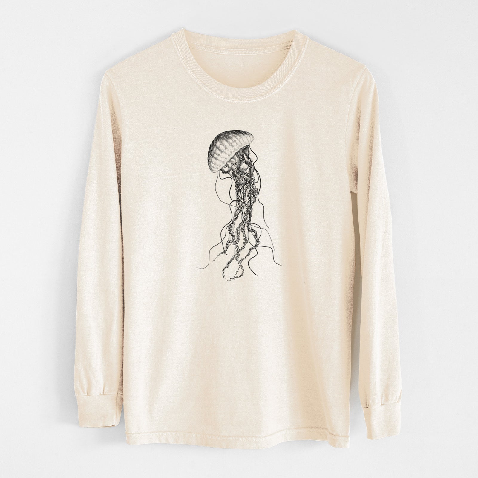 Ivory Comfort Colors long sleeve shirt laid flat, printed with a black ink illustration of a black sea nettle jellyfish with long trailing tentacles.