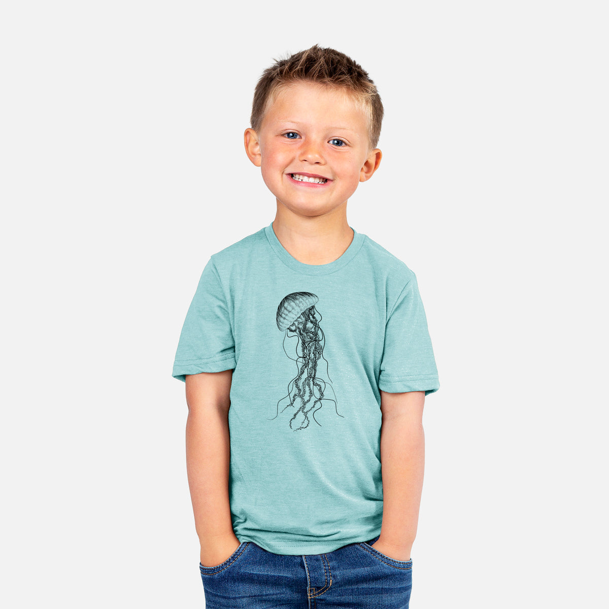 Smiling boy wearing a youth t-shirt printed with a black ink illustration of a black sea nettle jellyfish with long trailing tentacles.