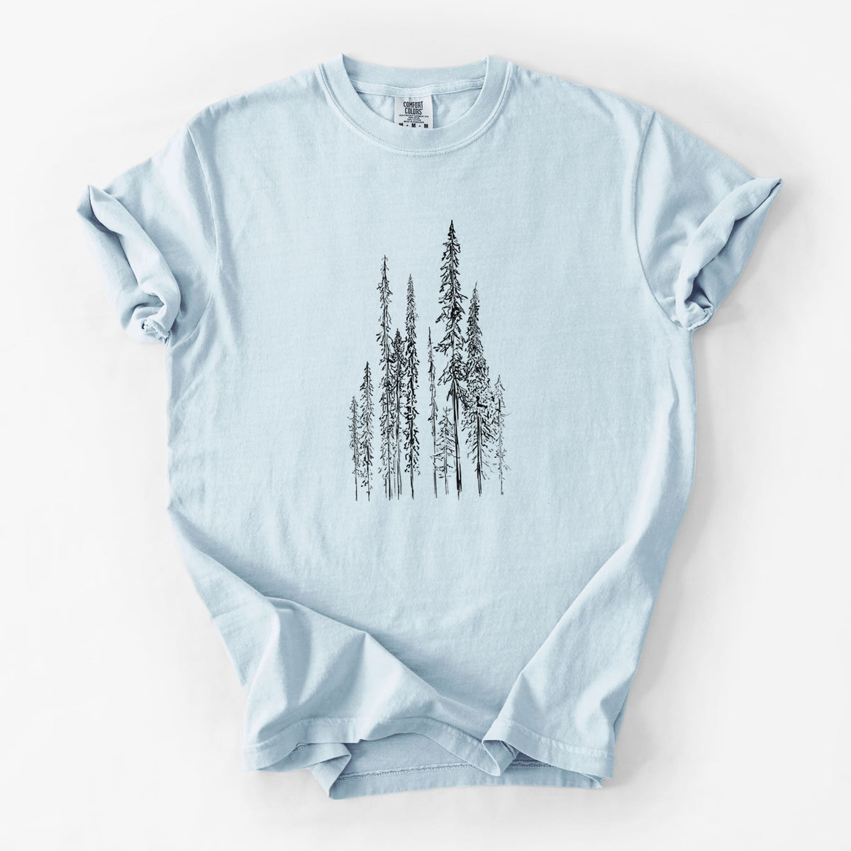 Chambray blue Comfort Colors t-shirt laid flat, printed with a black ink illustration of a stand of tall, narrow black spruce trees.