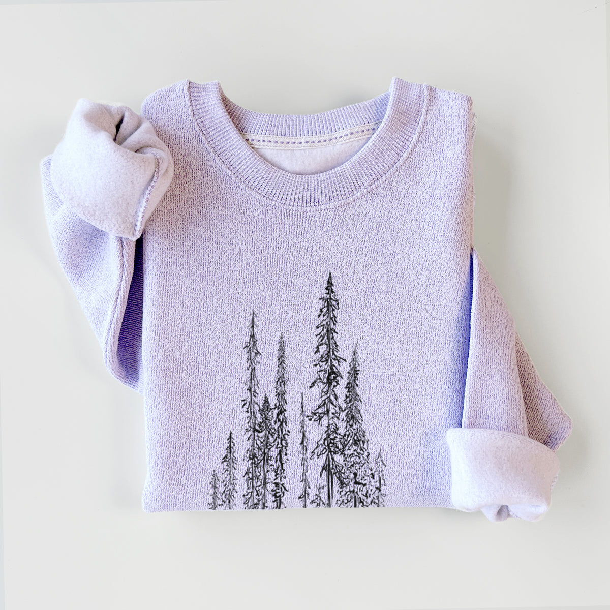 Ice purple knit sweatshirt printed with a black ink illustration of a stand of tall, narrow black spruce trees, styled flat.
