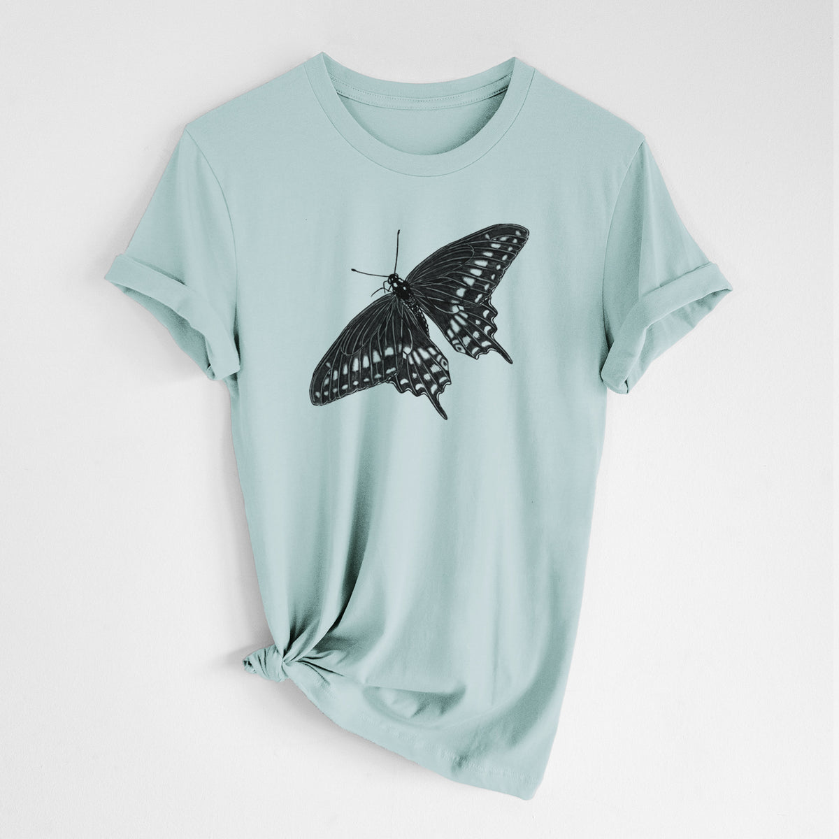 Dusty blue lightweight cotton t-shirt laid flat with the sleeves rolled, printed with a detailed black ink illustration of a black swallowtail butterfly with its wings spread.