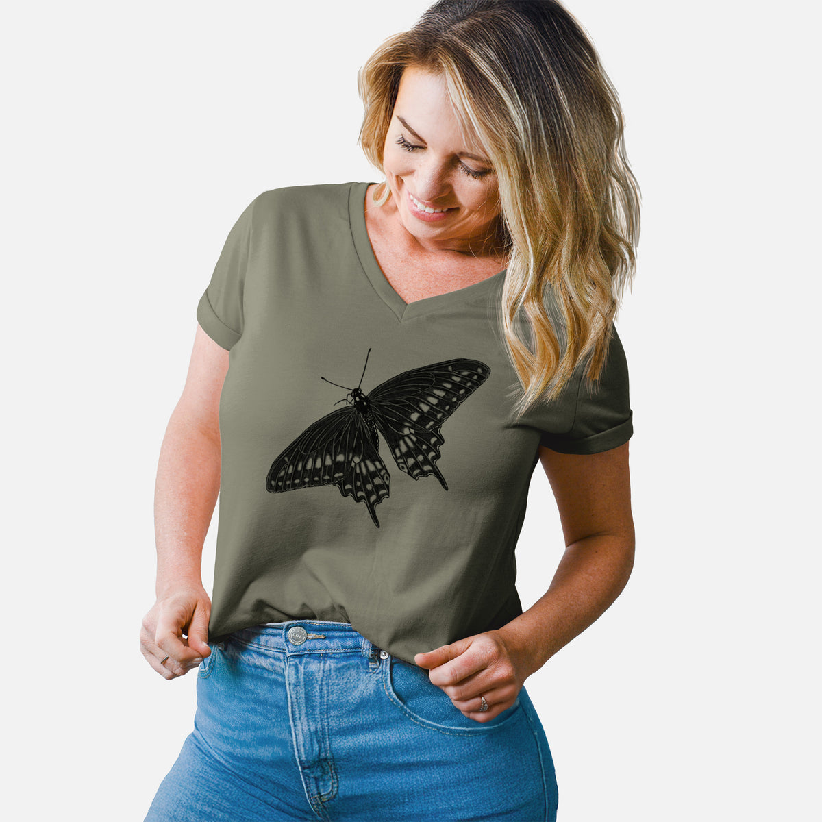 Woman wearing a military green women's relaxed fit cotton V-neck t-shirt printed with a detailed black ink illustration of a black swallowtail butterfly with its wings spread.
