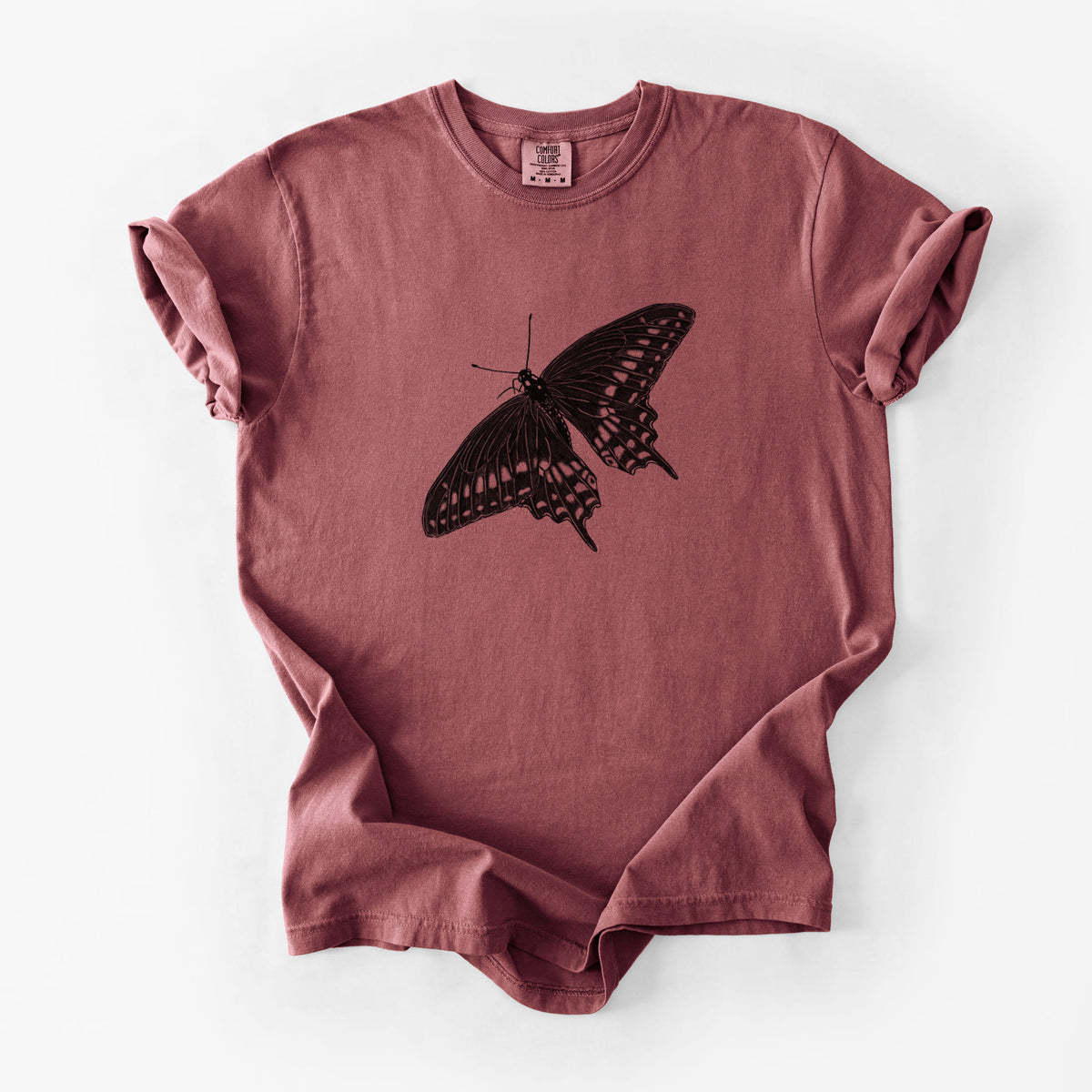 Brick red Comfort Colors t-shirt laid flat, printed with a detailed black ink illustration of a black swallowtail butterfly with its wings spread.