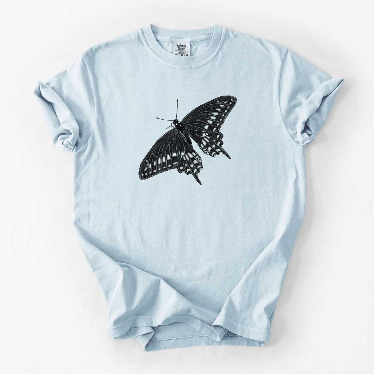 Chambray blue Comfort Colors t-shirt laid flat, printed with a detailed black ink illustration of a black swallowtail butterfly with its wings spread.