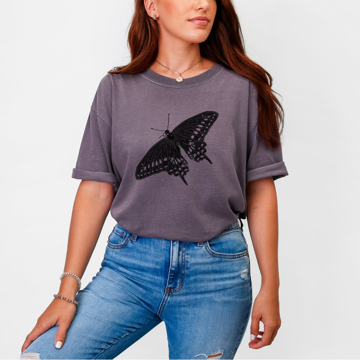 Woman wearing a Comfort Colors t-shirt printed with a detailed black ink illustration of a black swallowtail butterfly with its wings spread.