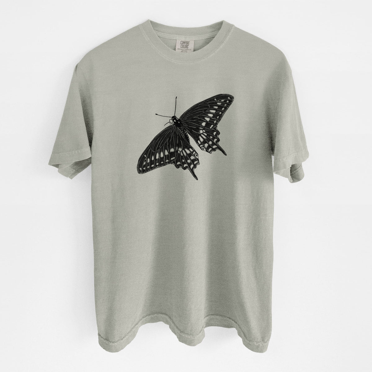 Sandstone beige Comfort Colors t-shirt laid flat, printed with a detailed black ink illustration of a black swallowtail butterfly with its wings spread.