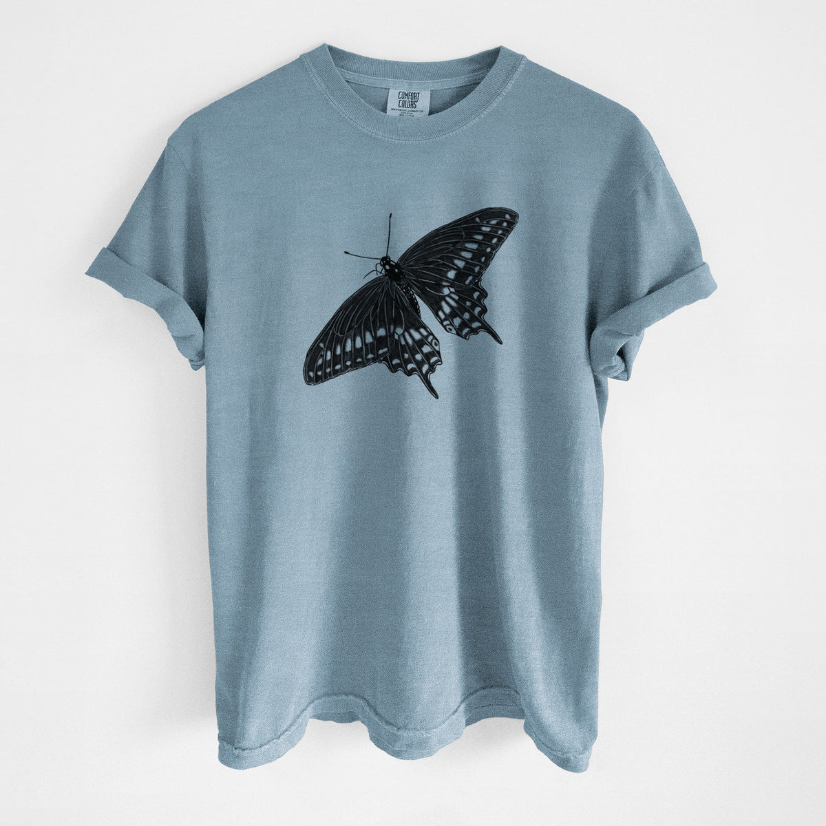 Steel blue Comfort Colors t-shirt laid flat, printed with a detailed black ink illustration of a black swallowtail butterfly with its wings spread.