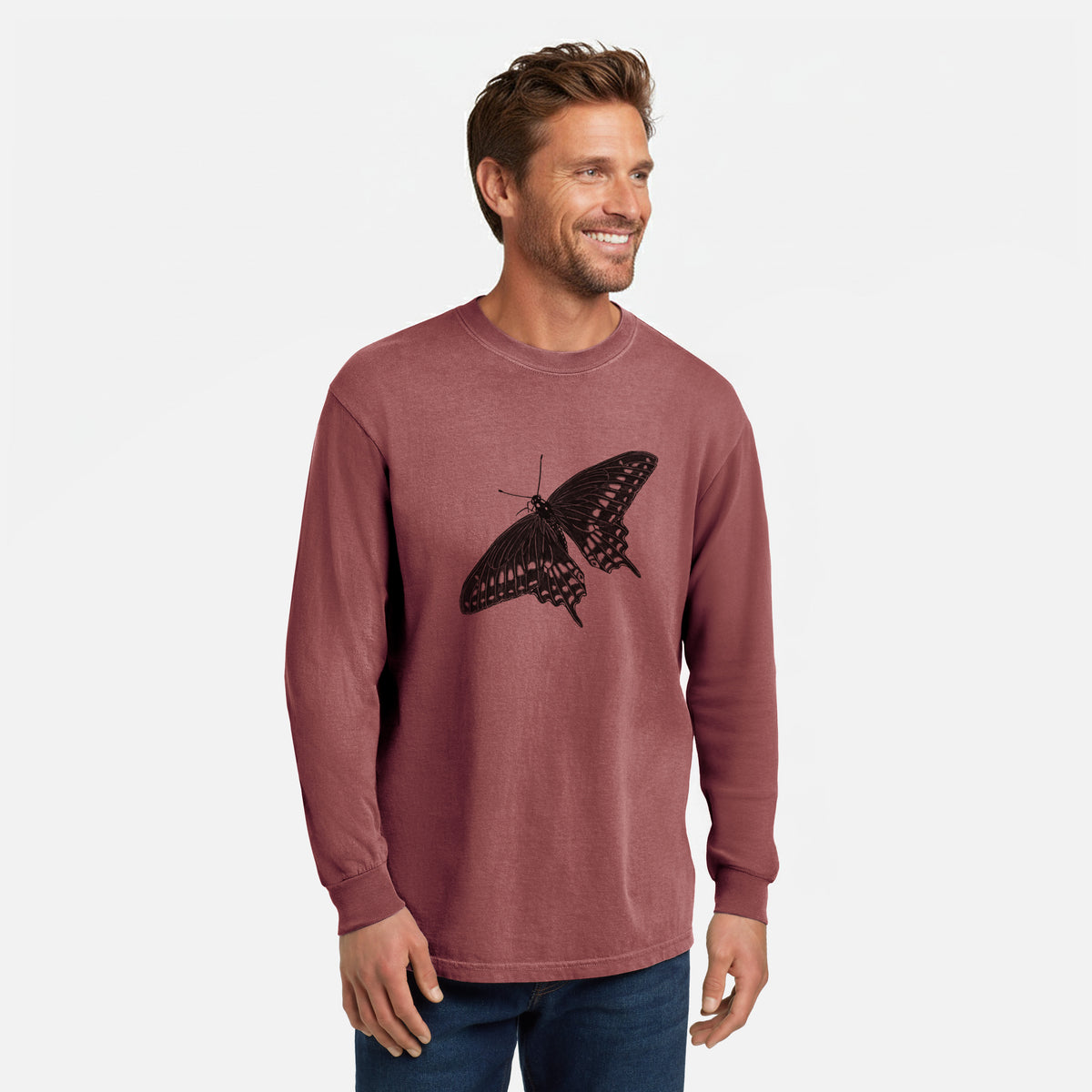 Brick red Comfort Colors long sleeve shirt printed with a detailed black ink illustration of a black swallowtail butterfly with its wings spread, shown in a lifestyle photo.