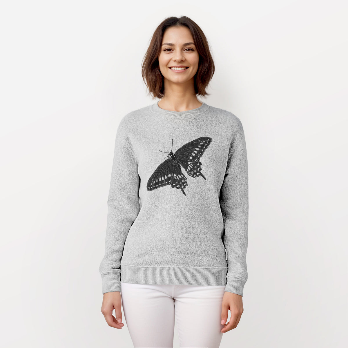 Woman wearing a knit sweatshirt printed with a detailed black ink illustration of a black swallowtail butterfly with its wings spread.
