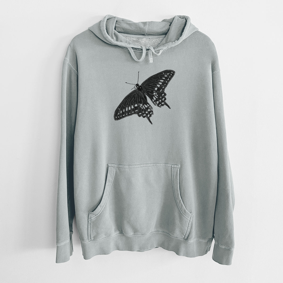 Sage green pigment dyed hoodie laid flat, printed with a detailed black ink illustration of a black swallowtail butterfly with its wings spread.