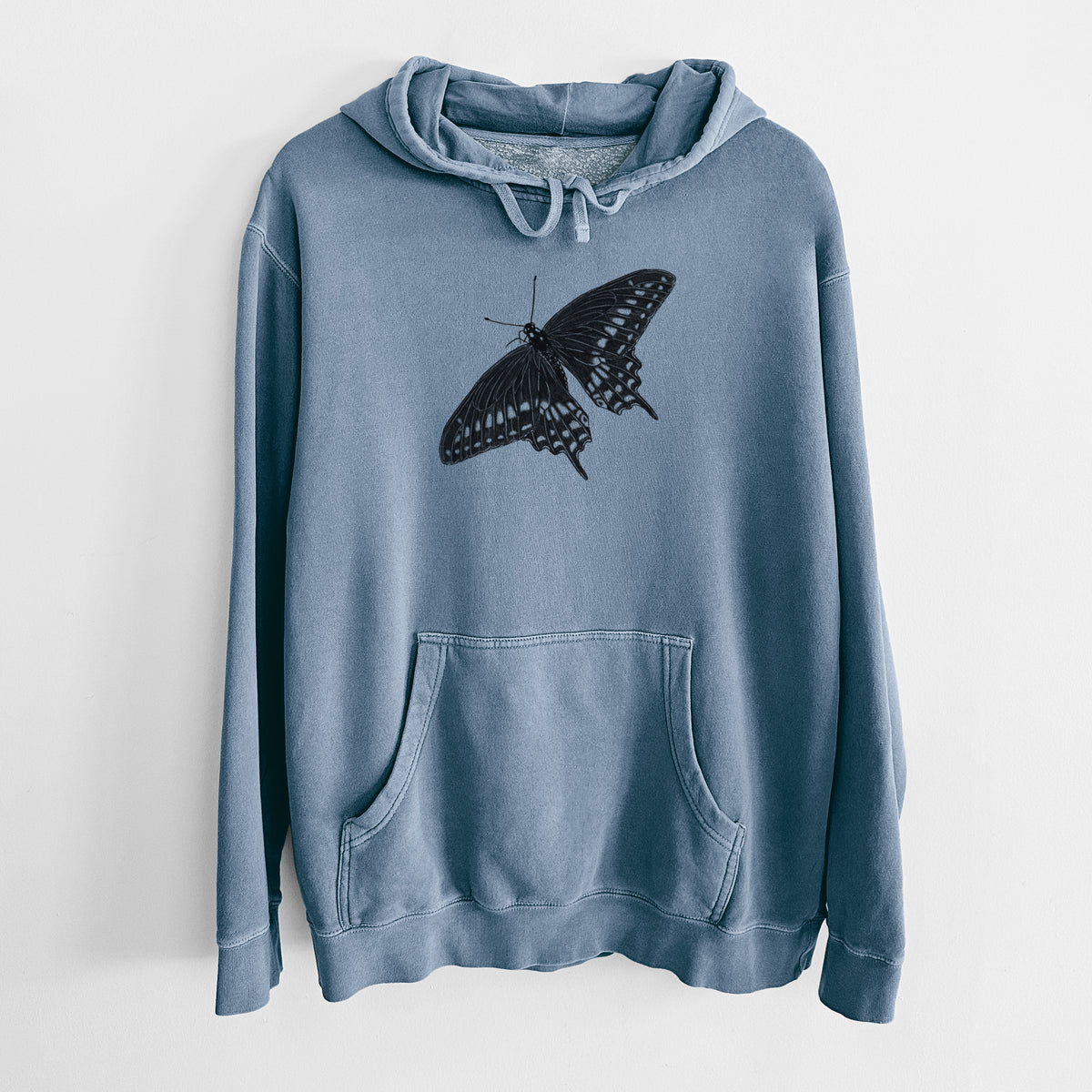 Slate blue pigment dyed hoodie laid flat, printed with a detailed black ink illustration of a black swallowtail butterfly with its wings spread.