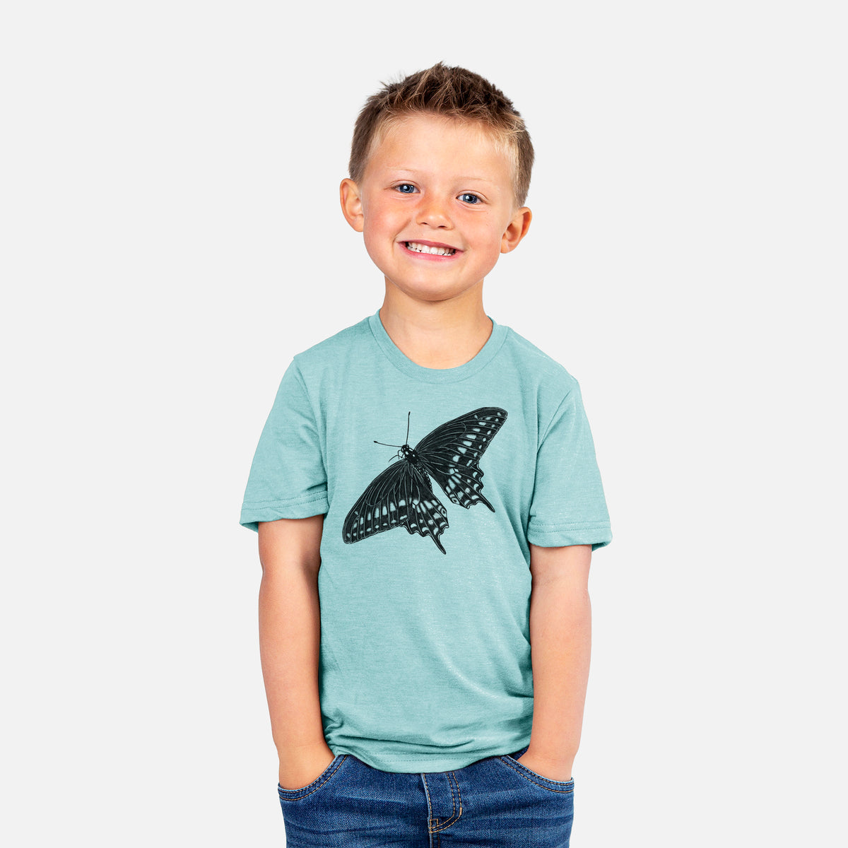 Smiling boy wearing a youth t-shirt printed with a detailed black ink illustration of a black swallowtail butterfly with its wings spread.