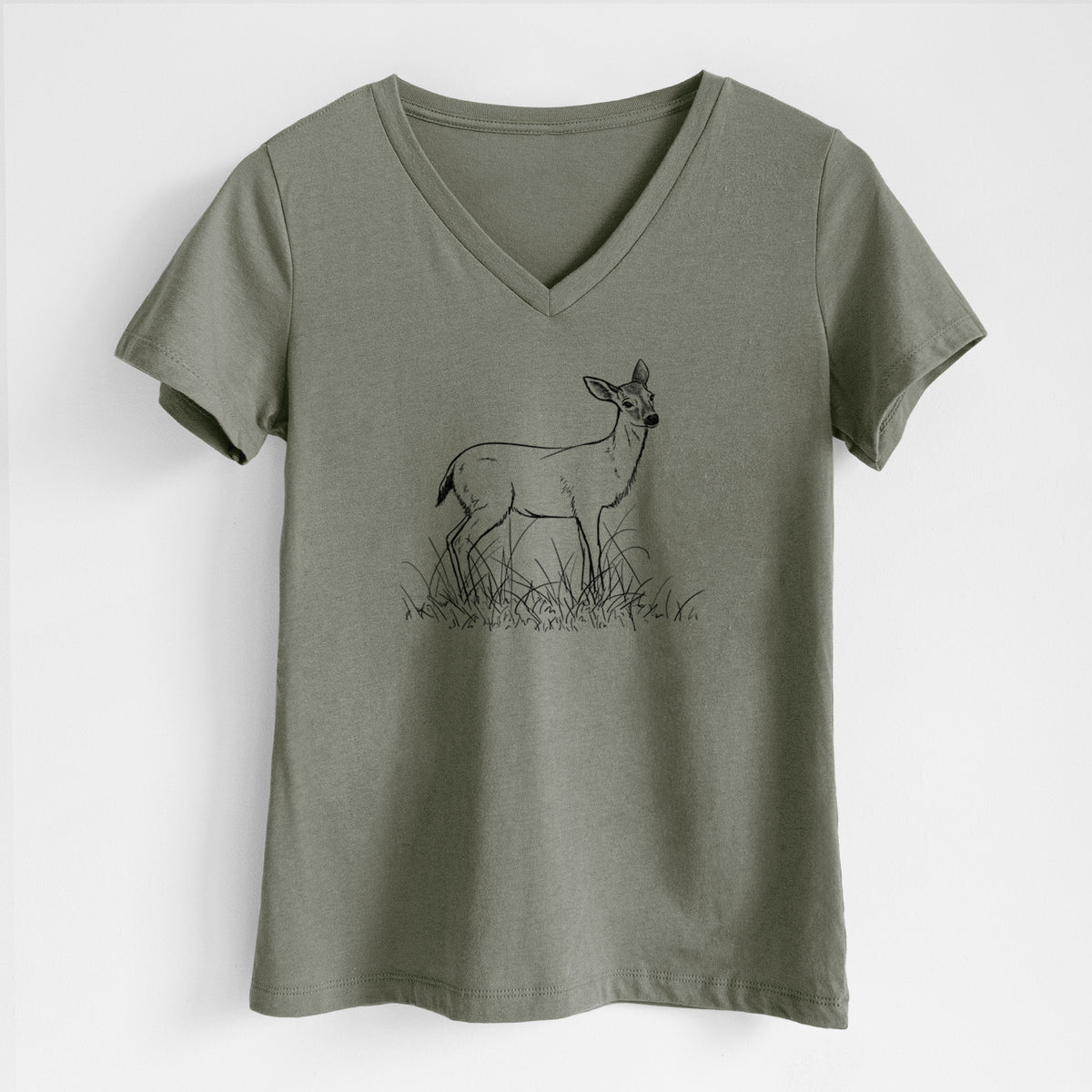 Military green women's relaxed fit cotton V-neck t-shirt laid flat, printed with a black ink sketch of a black-tailed deer standing in tall grass.