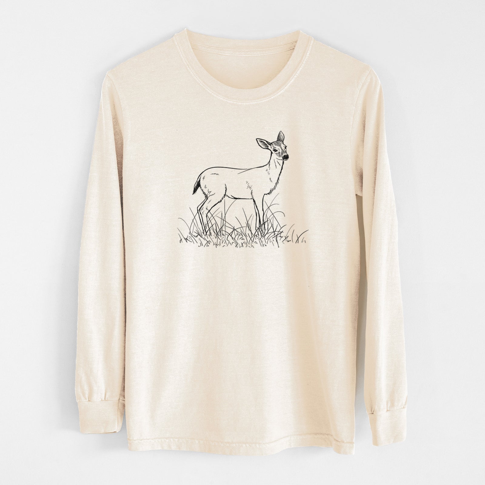 Ivory Comfort Colors long sleeve shirt laid flat, printed with a black ink sketch of a black-tailed deer standing in tall grass.