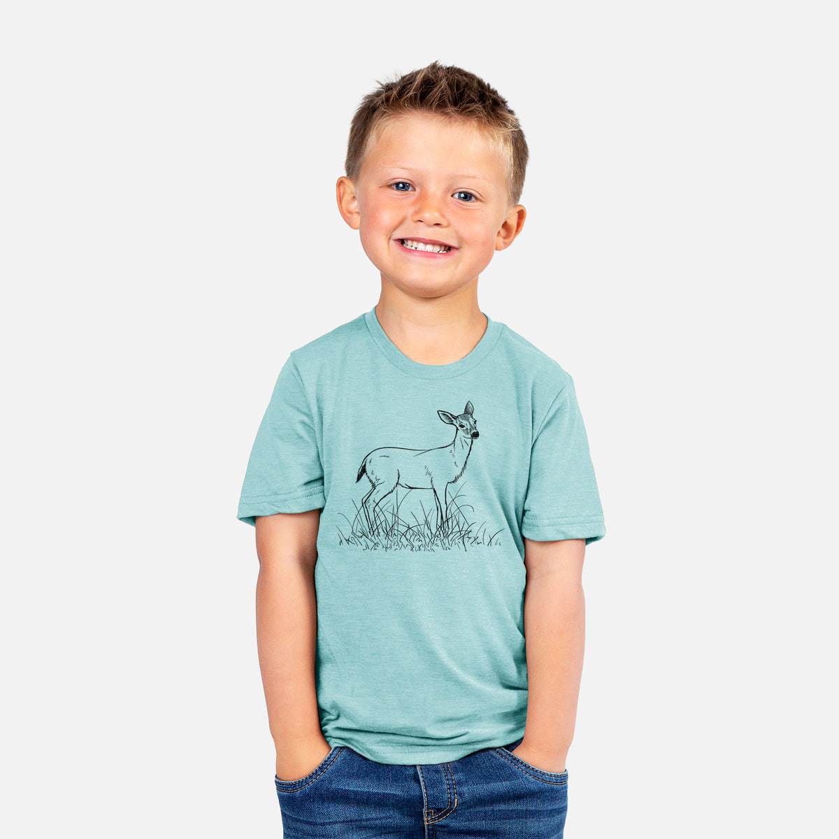 Smiling boy wearing a youth t-shirt printed with a black ink sketch of a black-tailed deer standing in tall grass.