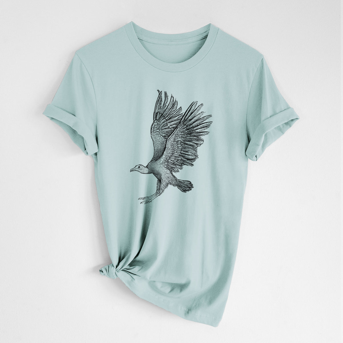 Dusty blue lightweight cotton t-shirt laid flat with the sleeves rolled, printed with a detailed black ink illustration of a black vulture landing with its wings spread.
