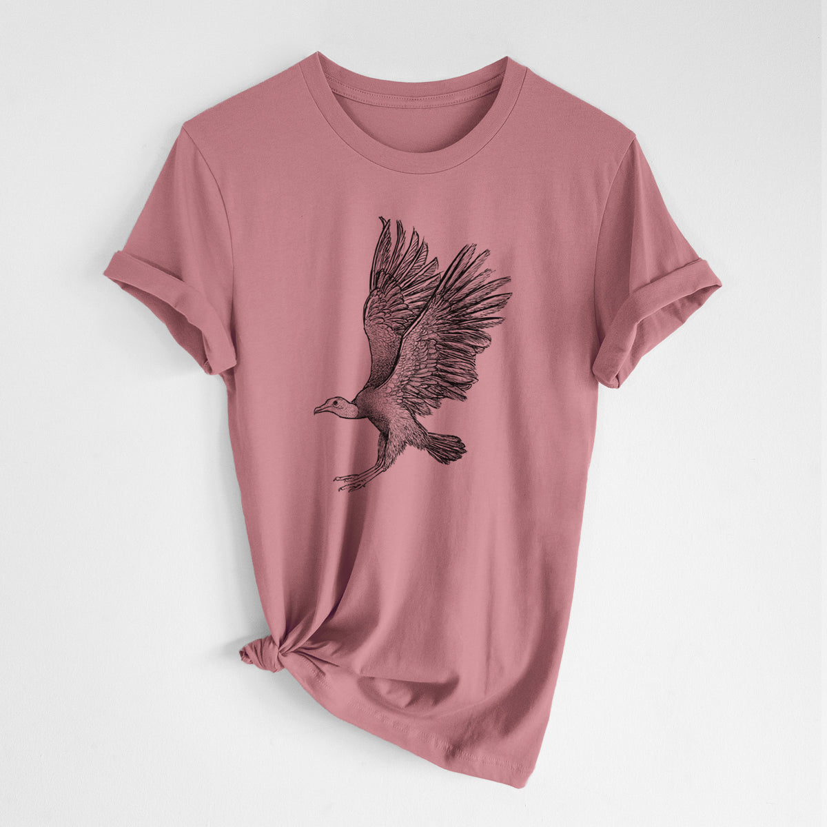 Mauve pink lightweight cotton t-shirt laid flat with the sleeves rolled, printed with a detailed black ink illustration of a black vulture landing with its wings spread.