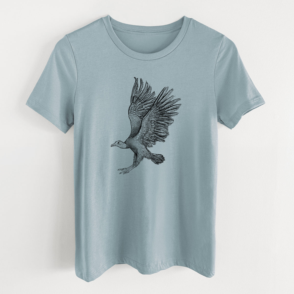 Vintage denim women's relaxed fit cotton t-shirt laid flat, printed with a detailed black ink illustration of a black vulture landing with its wings spread.