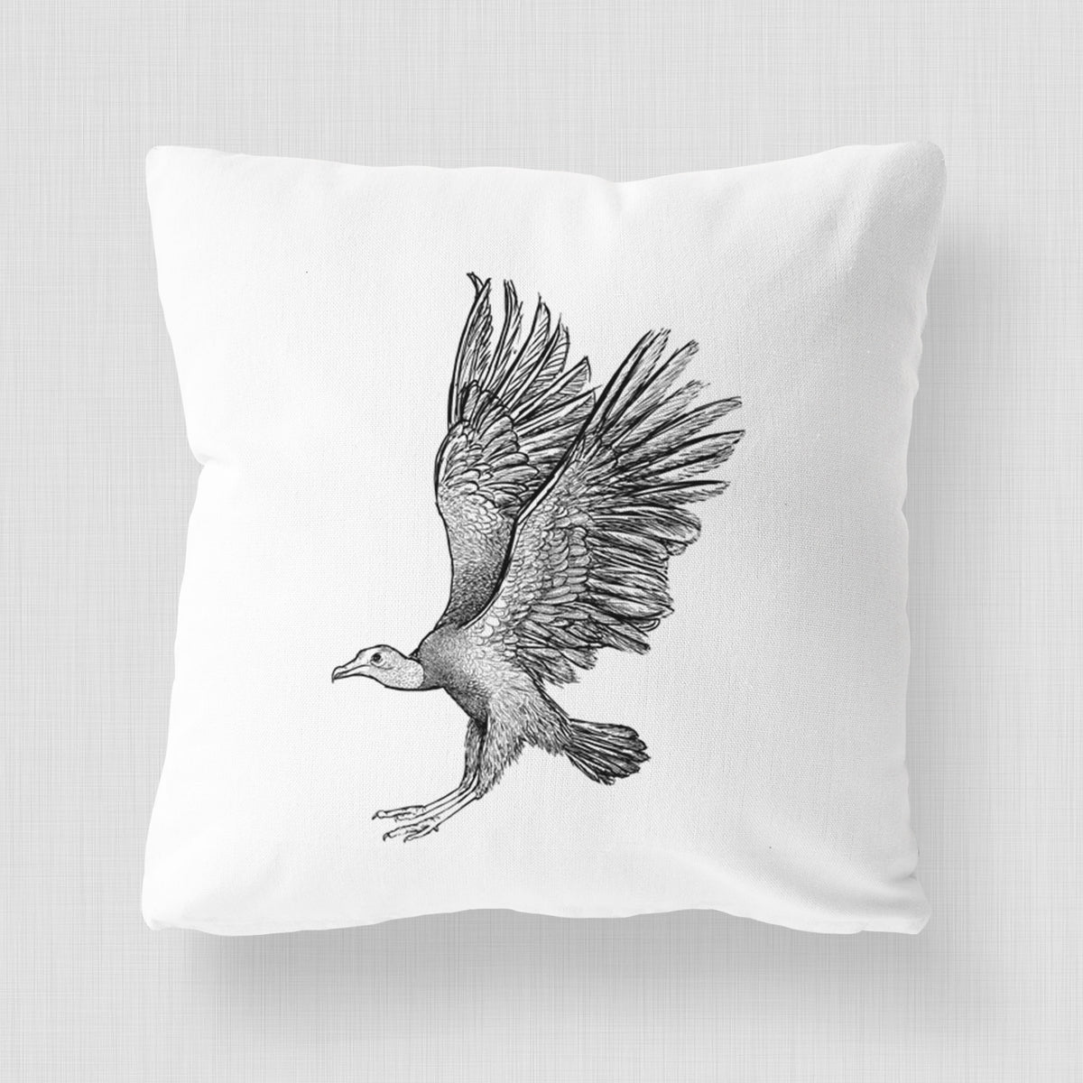 White pillow cover printed with a detailed black ink illustration of a black vulture landing with its wings spread.