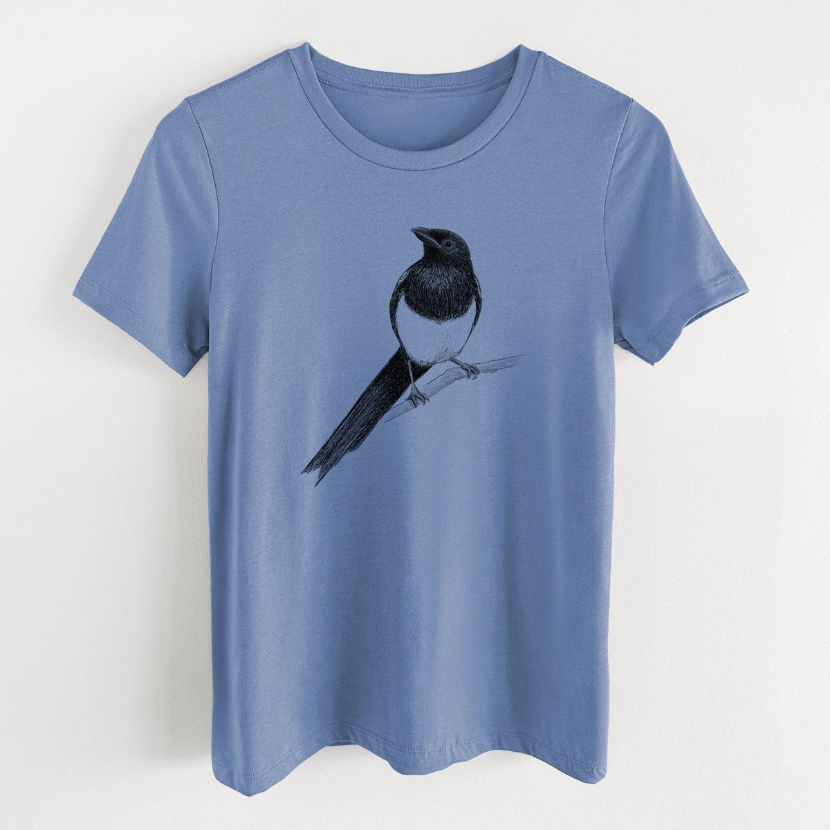 Blue bell women's relaxed fit cotton t-shirt laid flat, printed with a detailed black ink sketch of a black-billed magpie perched on a branch with its long tail.