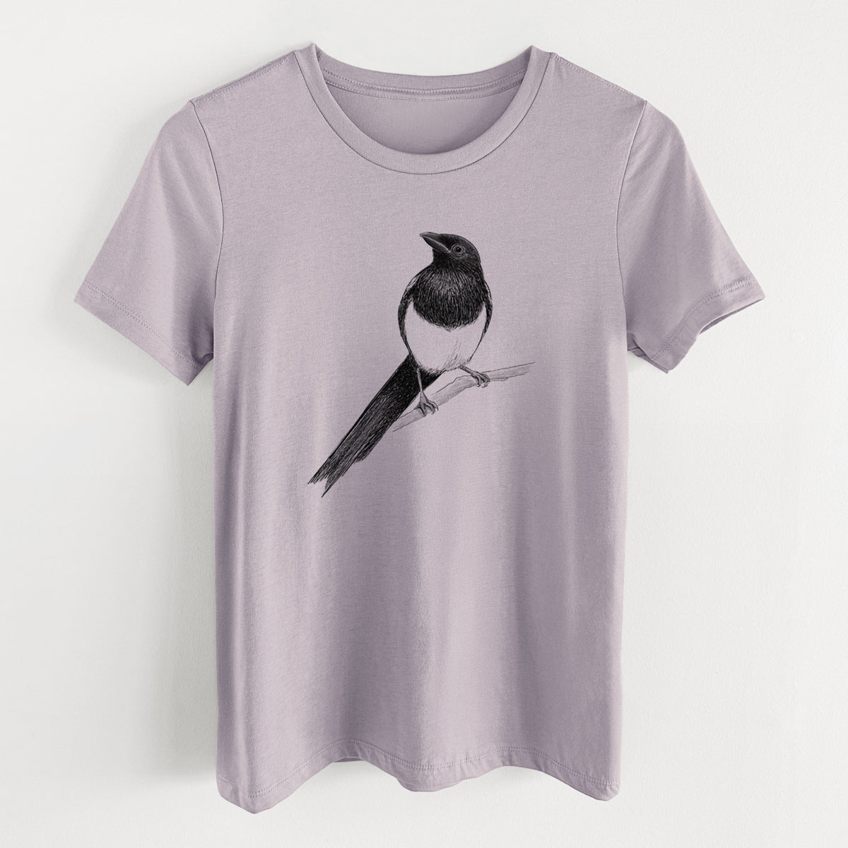 Light violet women's relaxed fit cotton t-shirt laid flat, printed with a detailed black ink sketch of a black-billed magpie perched on a branch with its long tail.