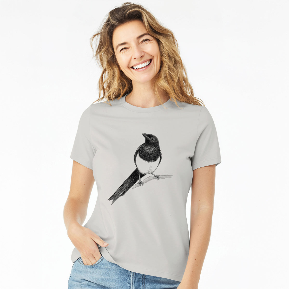 Woman wearing a lunar grey women's relaxed fit cotton t-shirt printed with a detailed black ink sketch of a black-billed magpie perched on a branch with its long tail.