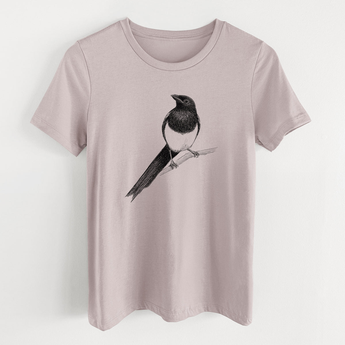 Pink gravel women's relaxed fit cotton t-shirt laid flat, printed with a detailed black ink sketch of a black-billed magpie perched on a branch with its long tail.