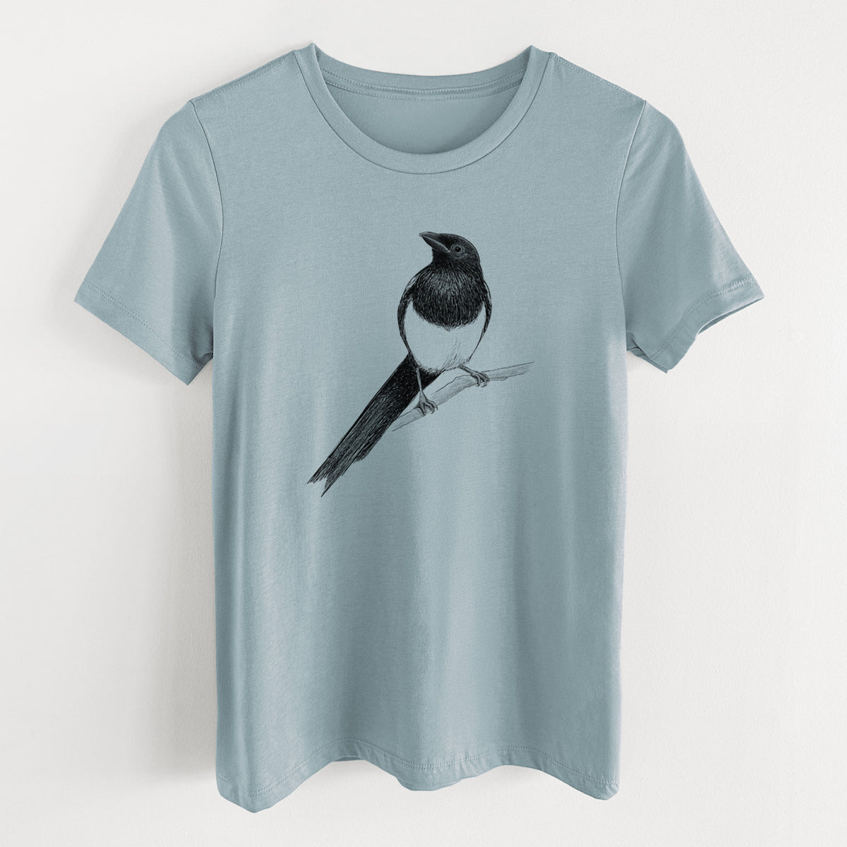 Vintage denim women's relaxed fit cotton t-shirt laid flat, printed with a detailed black ink sketch of a black-billed magpie perched on a branch with its long tail.