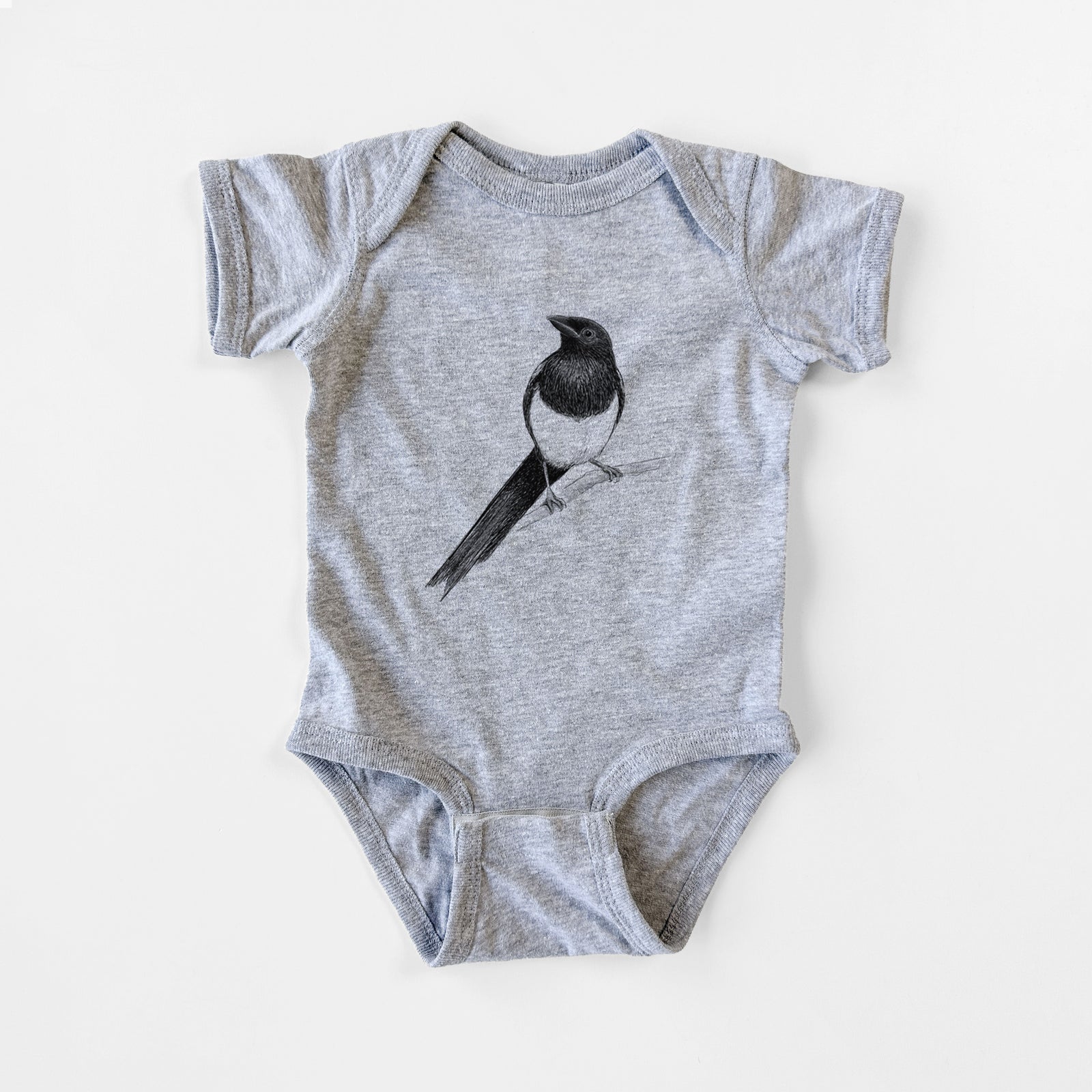Grey baby bodysuit laid flat, printed with a detailed black ink sketch of a black-billed magpie perched on a branch with its long tail.