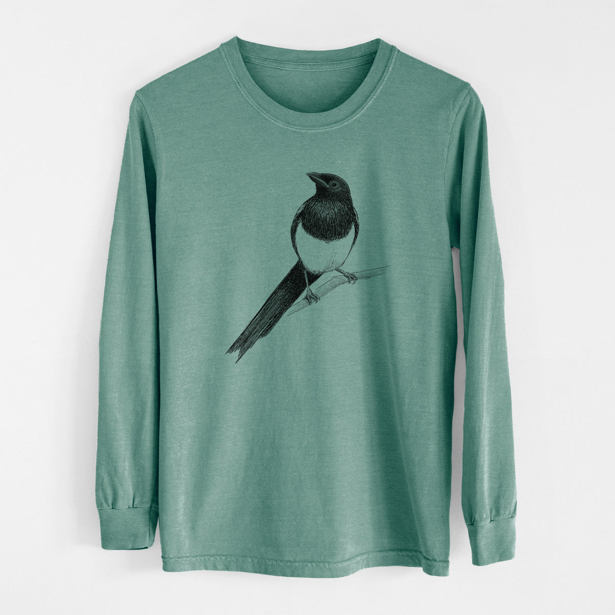 Pine green Comfort Colors long sleeve shirt laid flat, printed with a detailed black ink sketch of a black-billed magpie perched on a branch with its long tail.