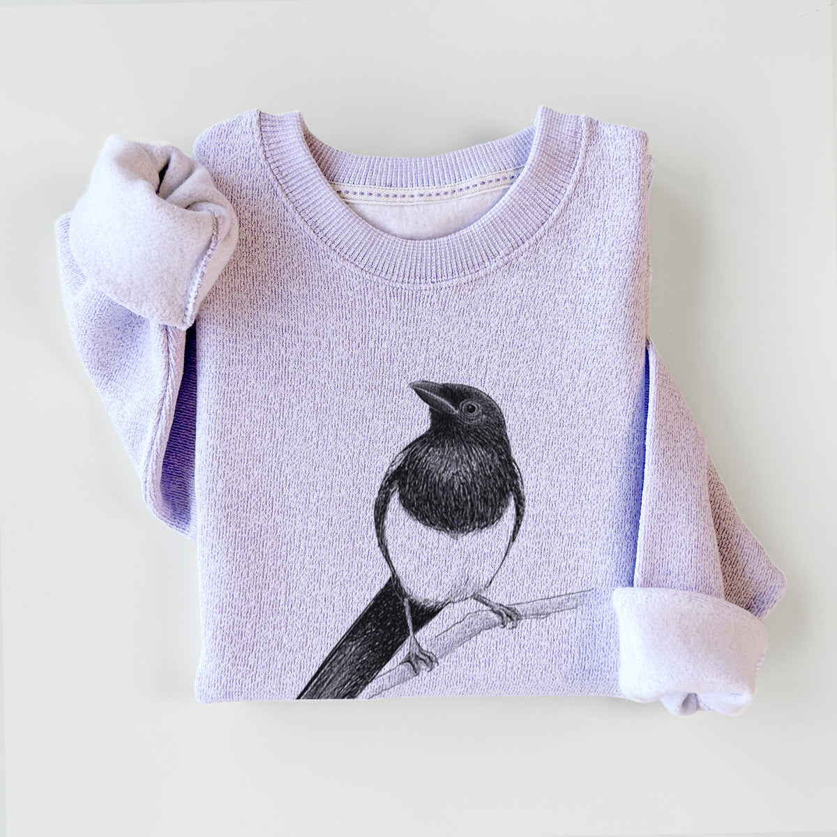Ice purple knit sweatshirt printed with a detailed black ink sketch of a black-billed magpie perched on a branch with its long tail, styled flat.