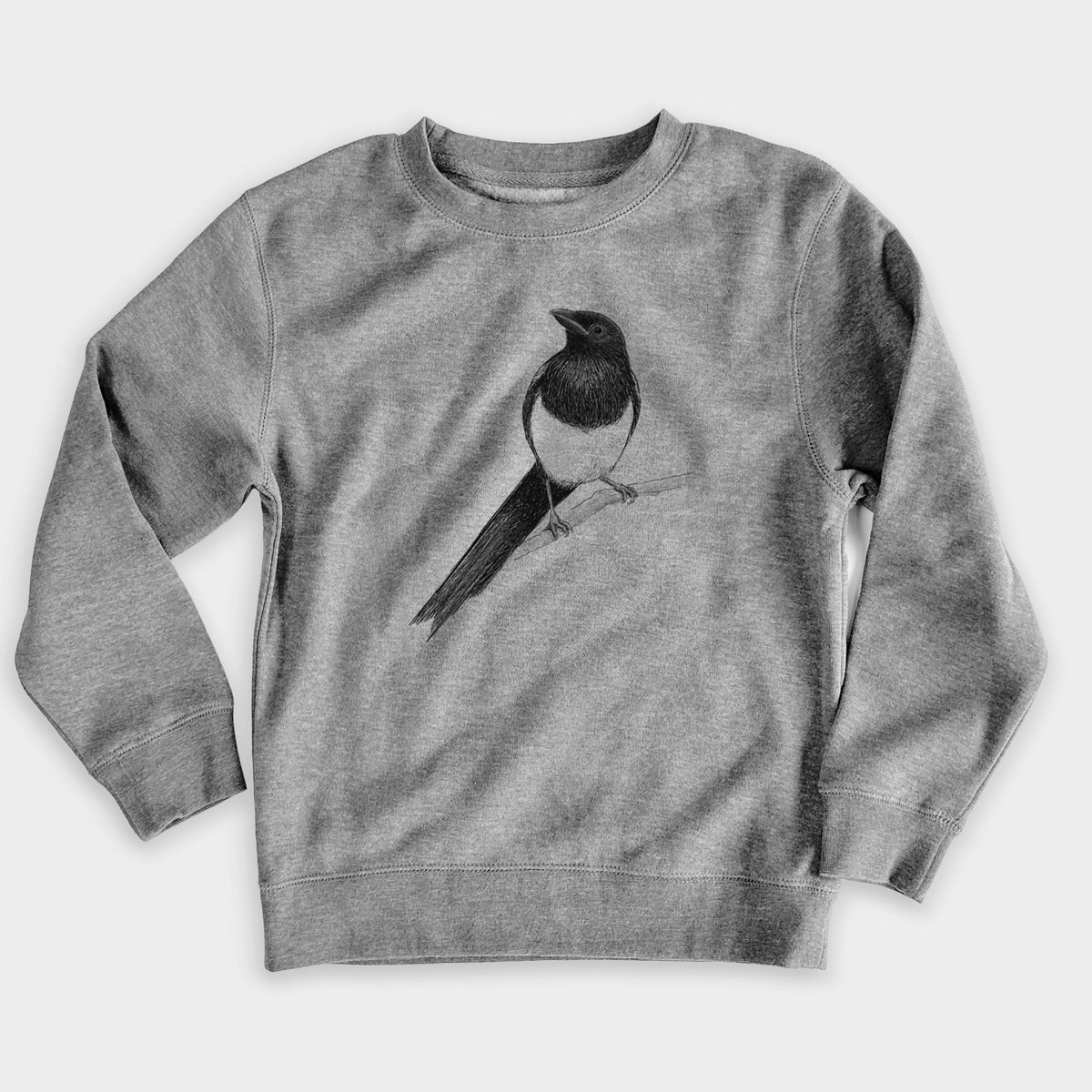 Nickel grey youth crewneck sweatshirt laid flat, printed with a detailed black ink sketch of a black-billed magpie perched on a branch with its long tail.
